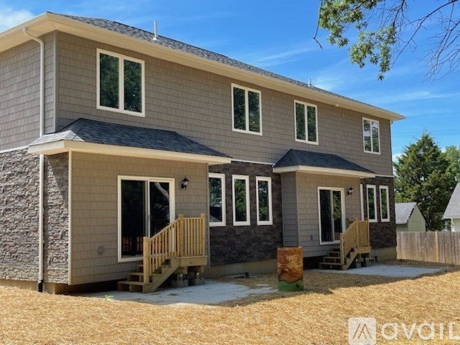 A two-story house with a grey exterior and a black roof.