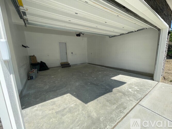 A spacious garage with a concrete floor and white walls.