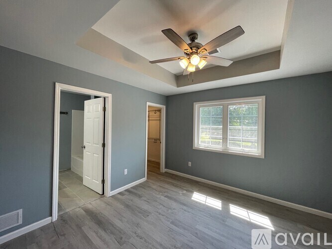 A room with a ceiling fan and a window.