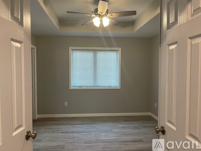 A room with a ceiling fan and a window.