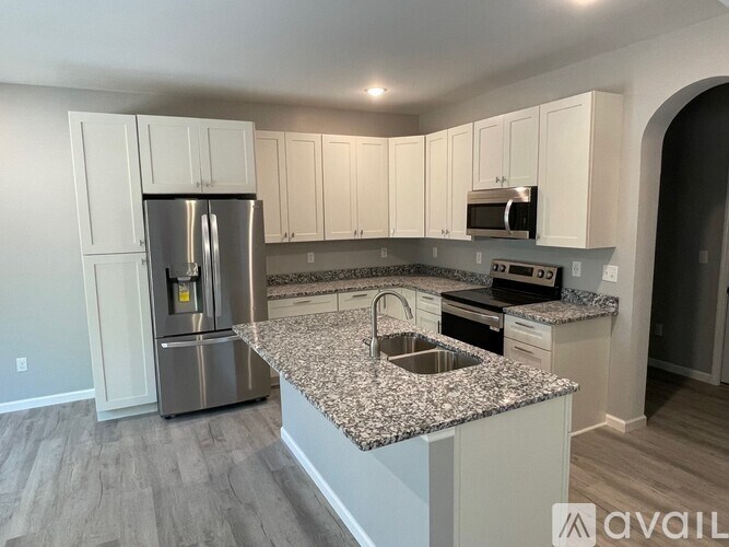 A kitchen with granite countertops and stainless steel appliances.