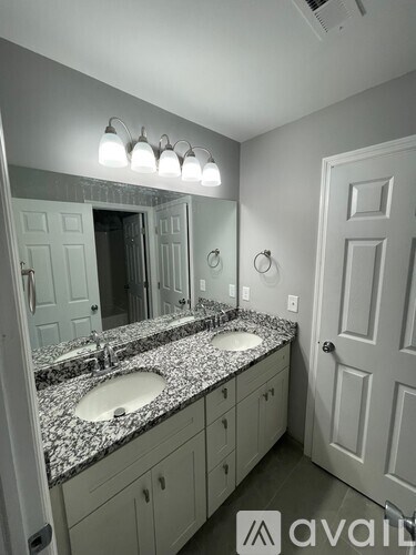 A bathroom with two sinks and a large mirror.
