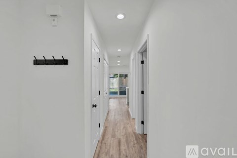 A long hallway with doors on both sides and a sign that says "available".