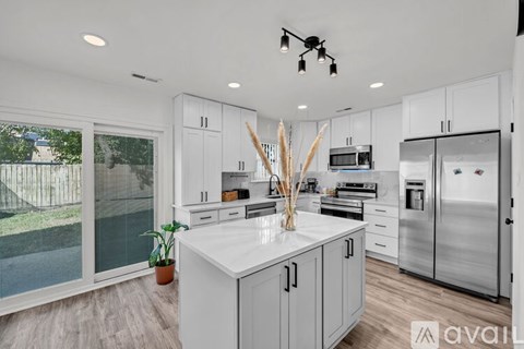 A modern kitchen with white cabinets and stainless steel appliances.