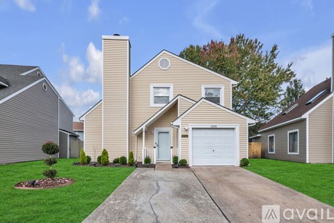 A beige house with a white garage door is for sale.