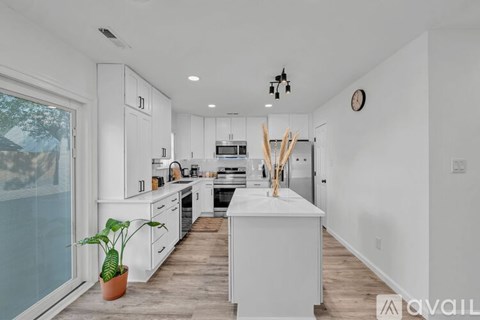 A modern kitchen with white cabinets and a large island.