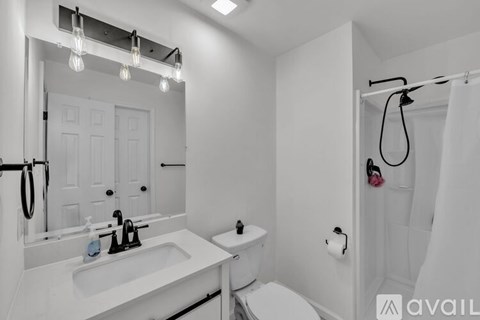 A bathroom with a white sink, toilet, and shower curtain.