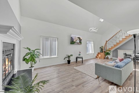 A living room with a fireplace, a couch, and a staircase.