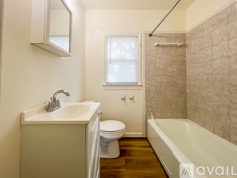 A bathroom with a white sink, toilet, and tub.