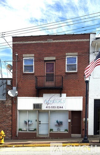 A red brick building with a white awning and a phone number on it.