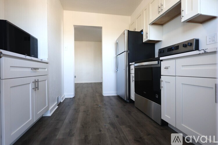A kitchen with black appliances and white cabinets.