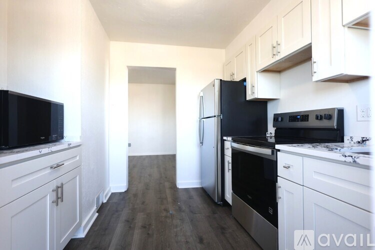 A kitchen with black appliances and white cabinets.