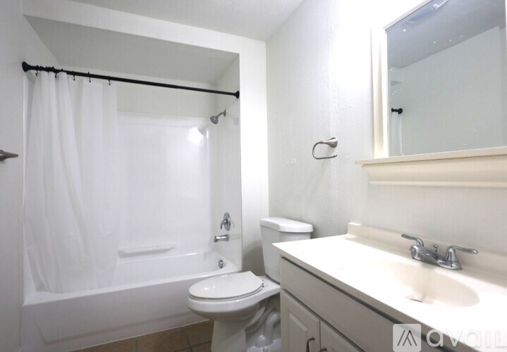 A white bathroom with a toilet, sink, and bathtub.