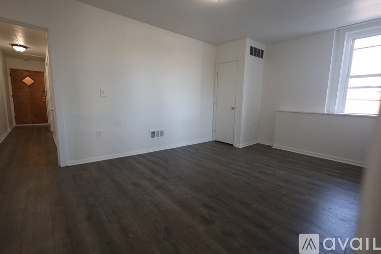 A room with wooden flooring and white walls.