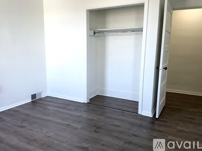 A room with a white wall and a white closet with a sliding door.