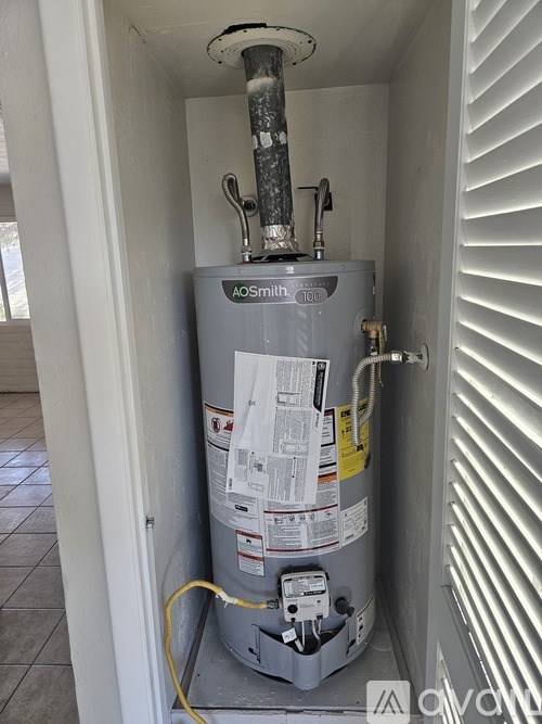 A tank with a gauge and a yellow cord.