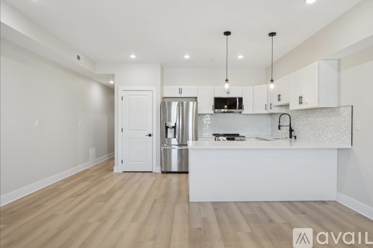 A kitchen with white cabinets and a wooden floor.