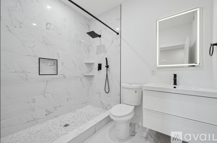 A white bathroom with a toilet, sink, and a marble wall.