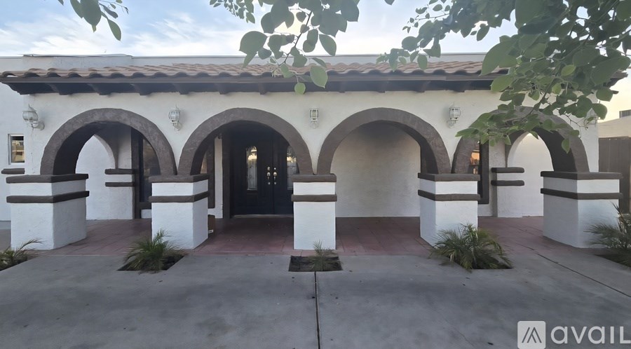 A building entrance with a black door and white pillars.