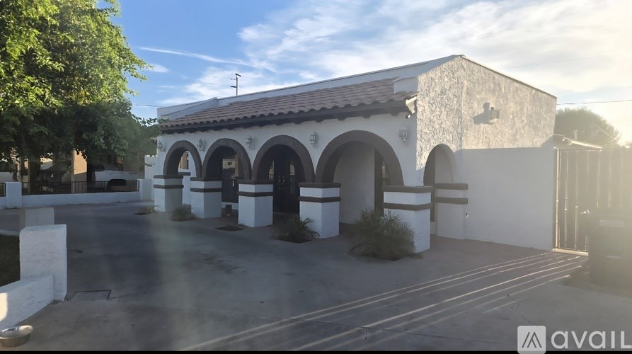 A building with arches and a sign that says "available" in the foreground.