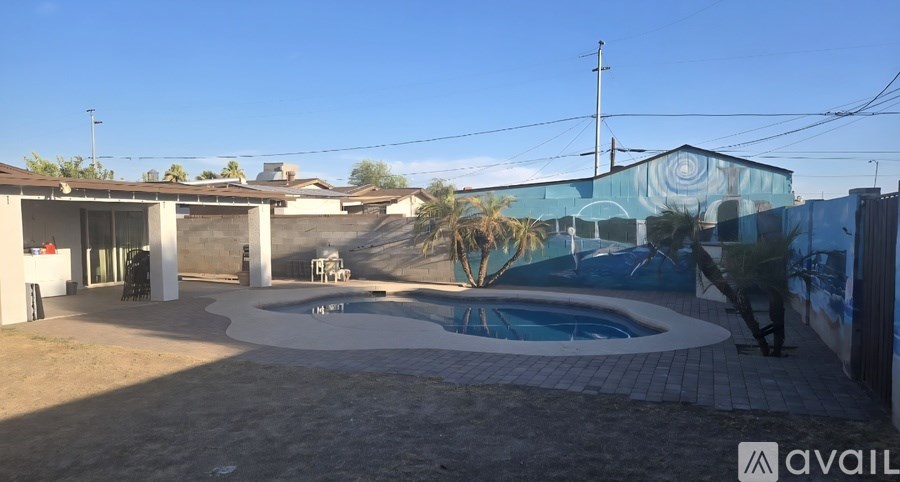 A pool surrounded by a patio and a house.