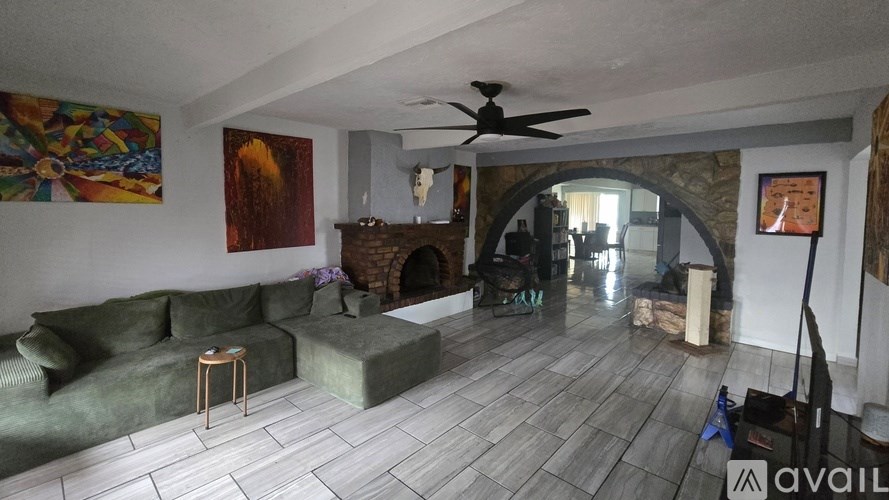 A living room with a fireplace and a painting on the wall.