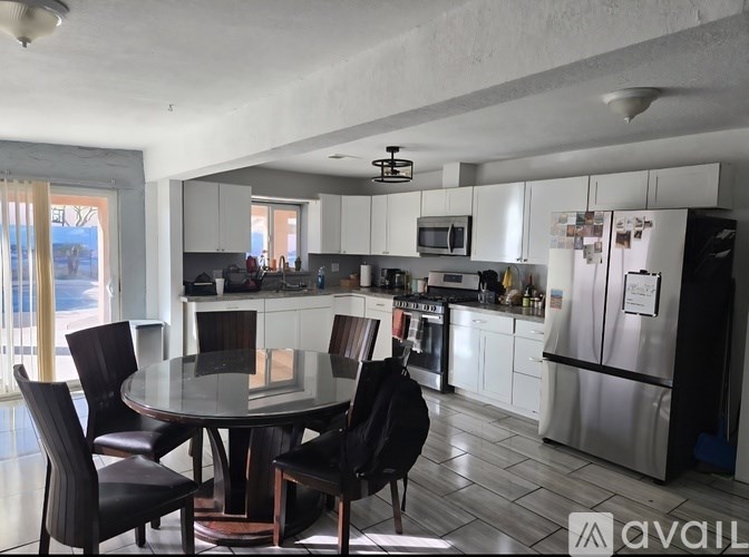 A modern kitchen with a glass table and chairs.