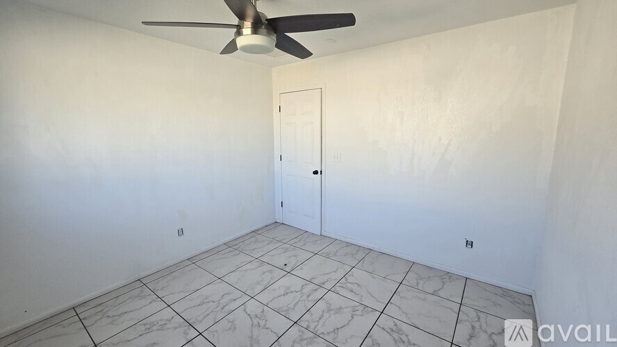 A room with a ceiling fan and a closed door.