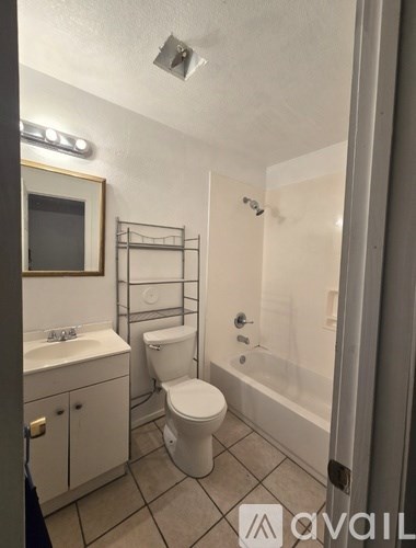 A bathroom with a toilet, sink, and mirror.