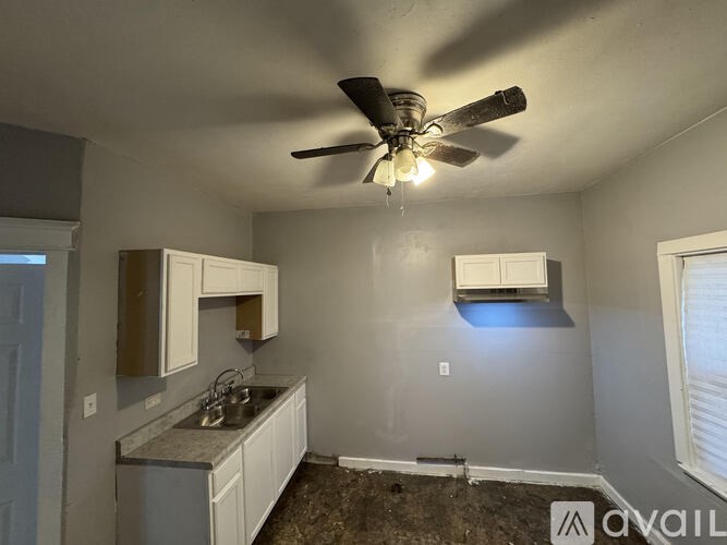A kitchen with a fan and a window.