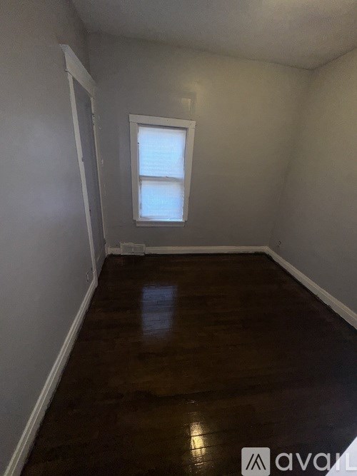 A room with wooden floors and a small window.