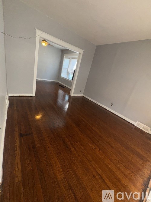 A room with wooden flooring and a window.
