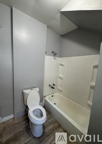 A white toilet and bathtub in a small bathroom.