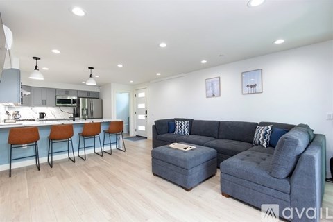 A modern living room with a grey sofa and a bar area.