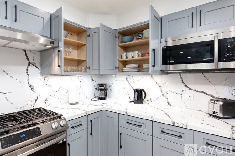 A kitchen with a marble countertop and stainless steel appliances.