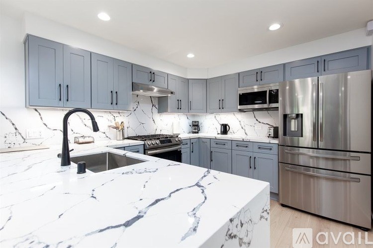 A kitchen with marble countertops and stainless steel appliances.