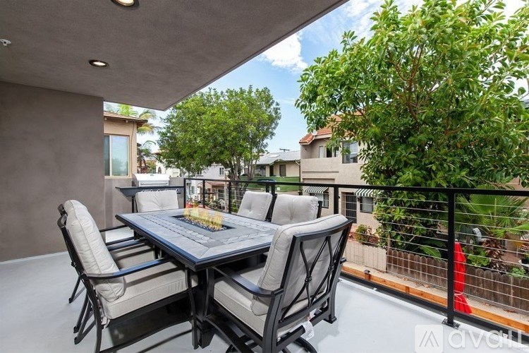 A patio with a table and chairs overlooking a fence.