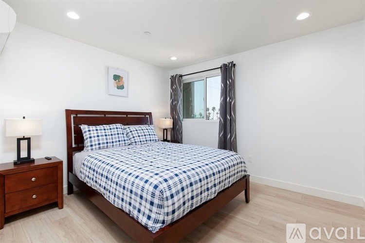 A bedroom with a bed, nightstand, and lamp.