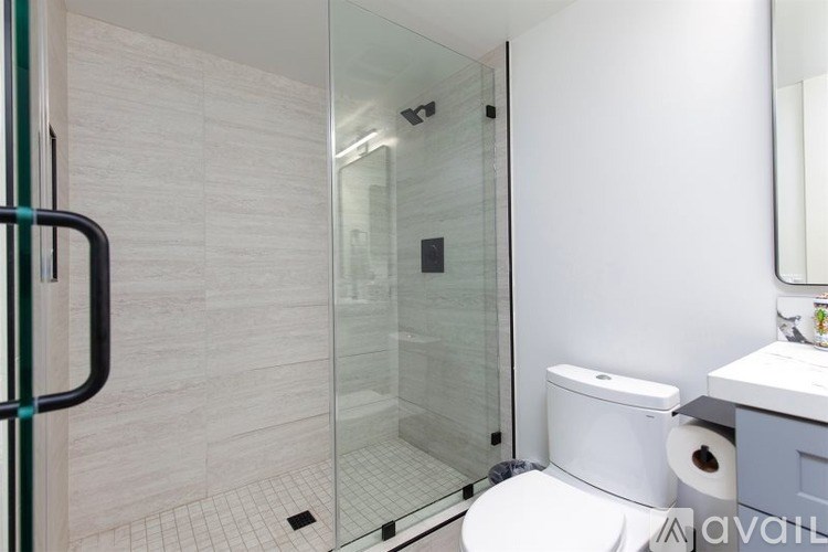 A bathroom with a toilet, sink, and glass shower door.