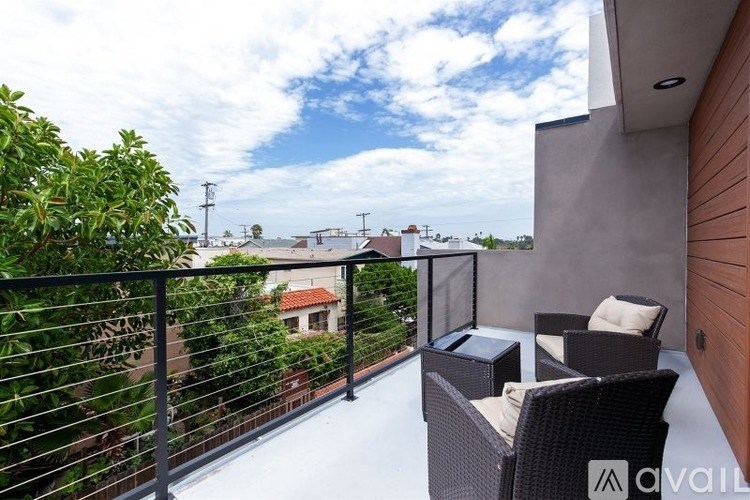 A balcony with a table and chairs overlooking a residential area.