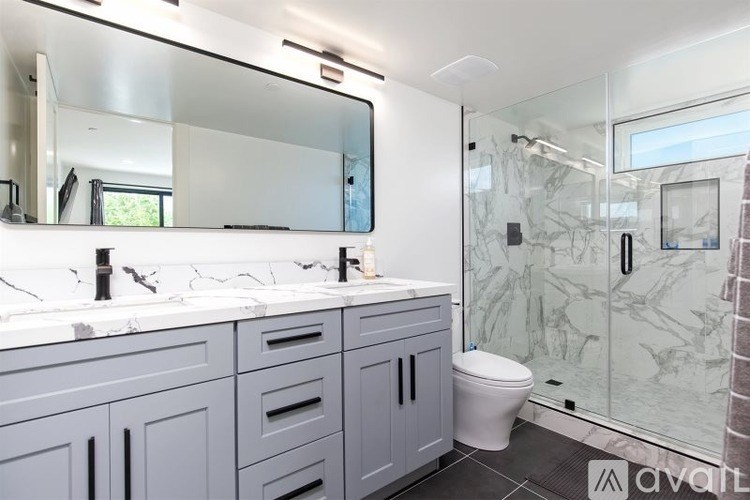 A bathroom with a marble wall and a white sink.