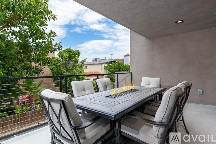 A table with chairs and a fire pit on a balcony.