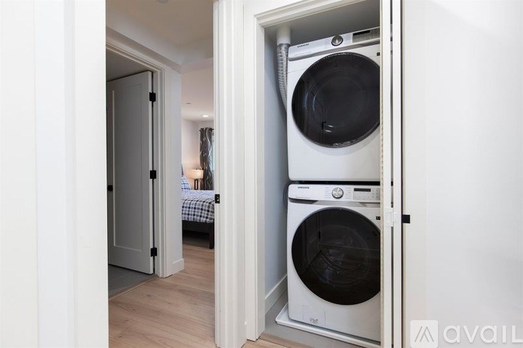 A white dryer is in a small room with a door open.