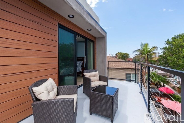 A patio with a table and chairs is set up on a balcony.