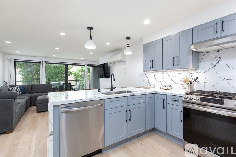 A modern kitchen with a large island and stainless steel appliances.