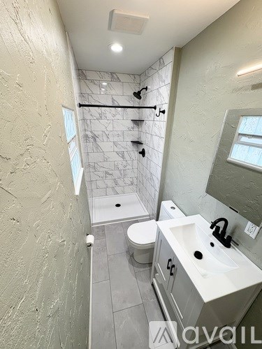 A bathroom with a white sink and a walk-in shower.