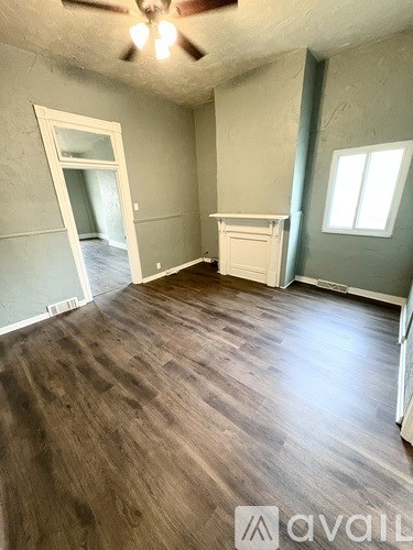 A room with wooden flooring and a ceiling fan.
