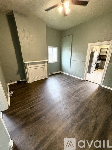 A room with wooden flooring and a ceiling fan.