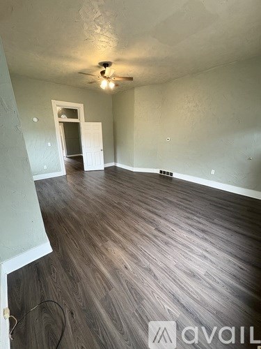 A room with wooden flooring and a ceiling fan.