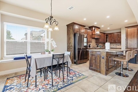 A kitchen with a dining table and chairs.